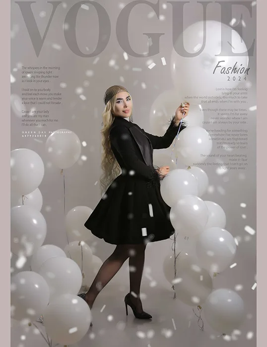 Woman in a black dress posing among white balloons during a birthday portrait session