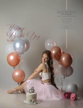 Woman in a pink skirt seated among pink, rose-gold and silver balloons during a birthday portrait session