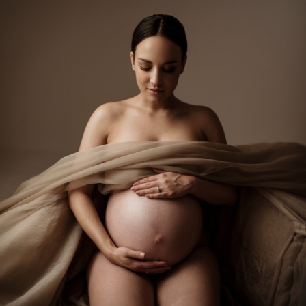 Artistic maternity photography in a Toronto studio showing a pregnant woman with visible baby bump and soft professional lighting