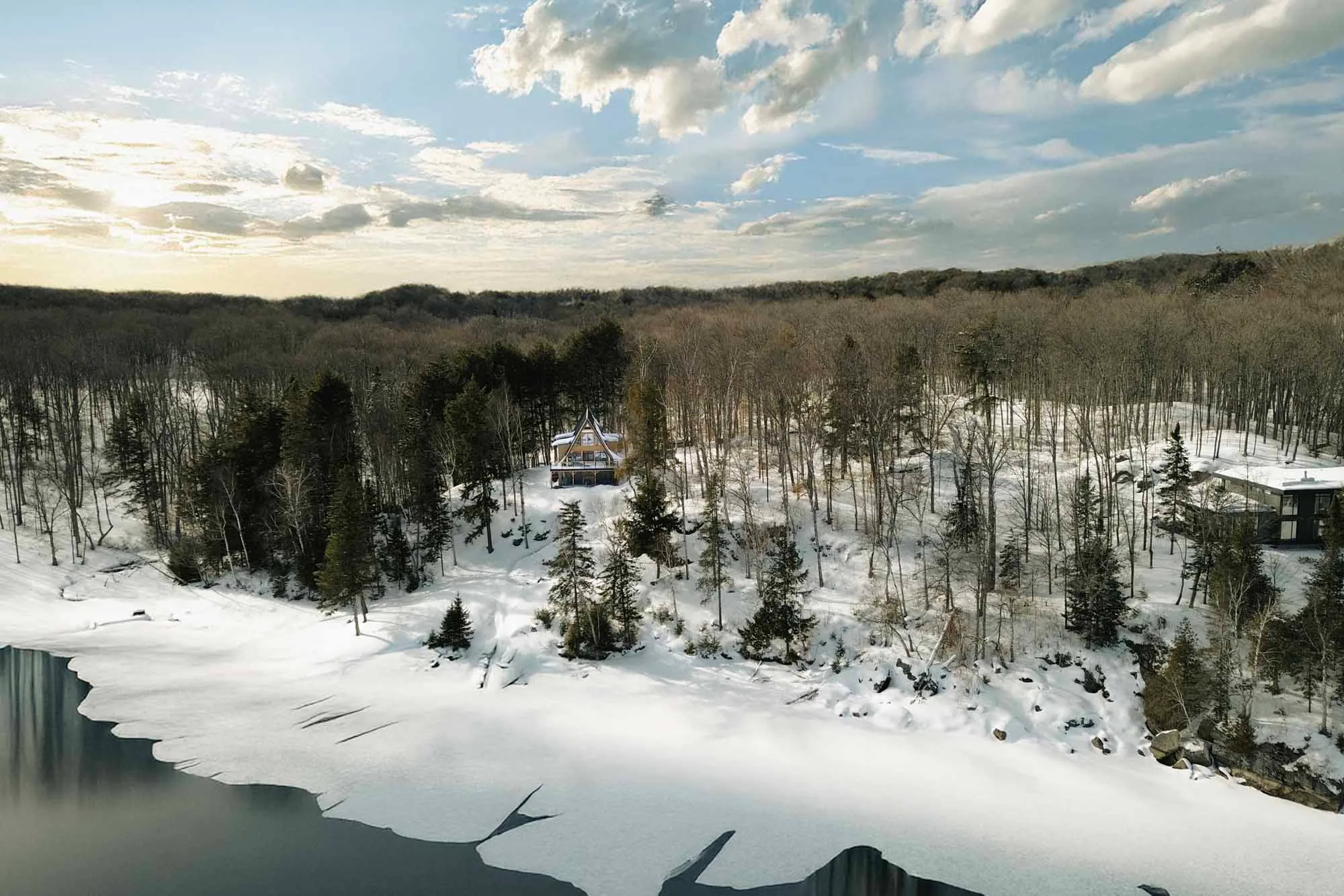 Wide aerial drone view of a waterfront property and its surrounding landscape