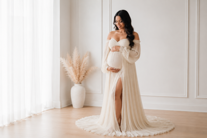 Pregnant woman wearing flowing maternity gown during studio session