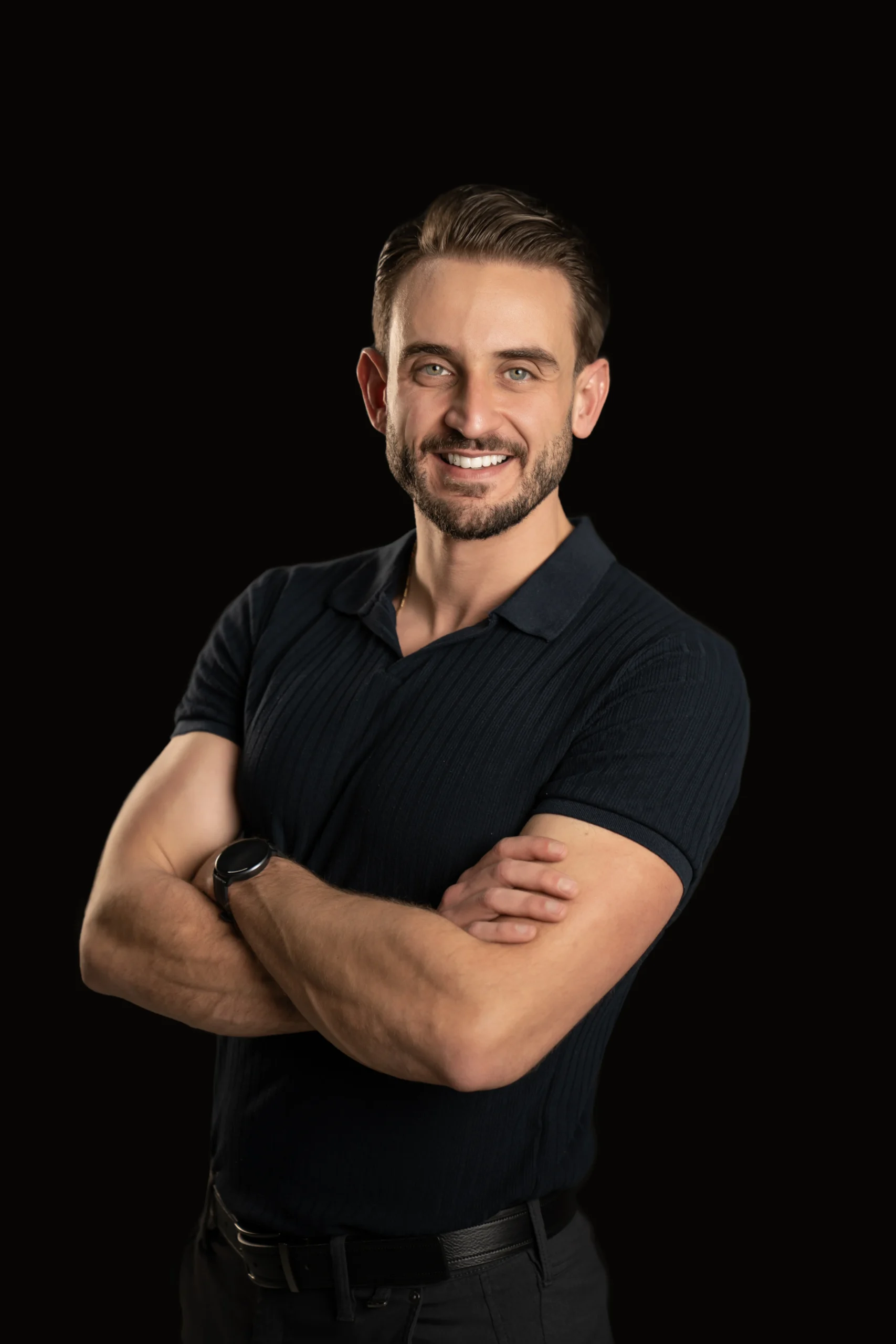 Approachable male professional smiling in a black-background LinkedIn portrait