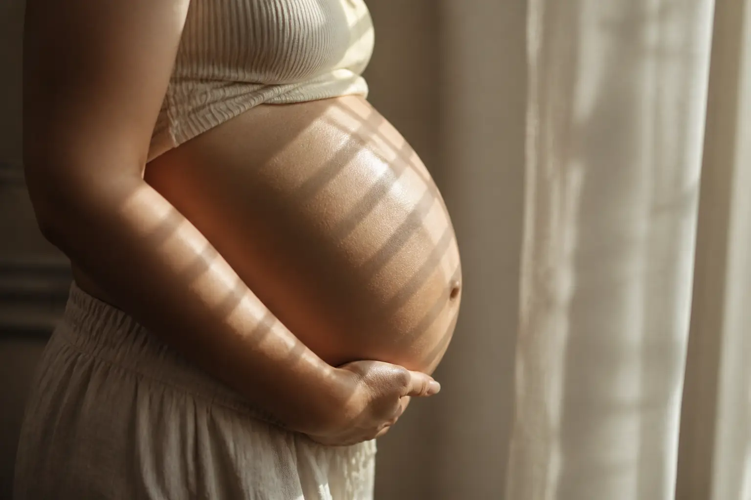 Artistic maternity portrait using soft window light in a Toronto home