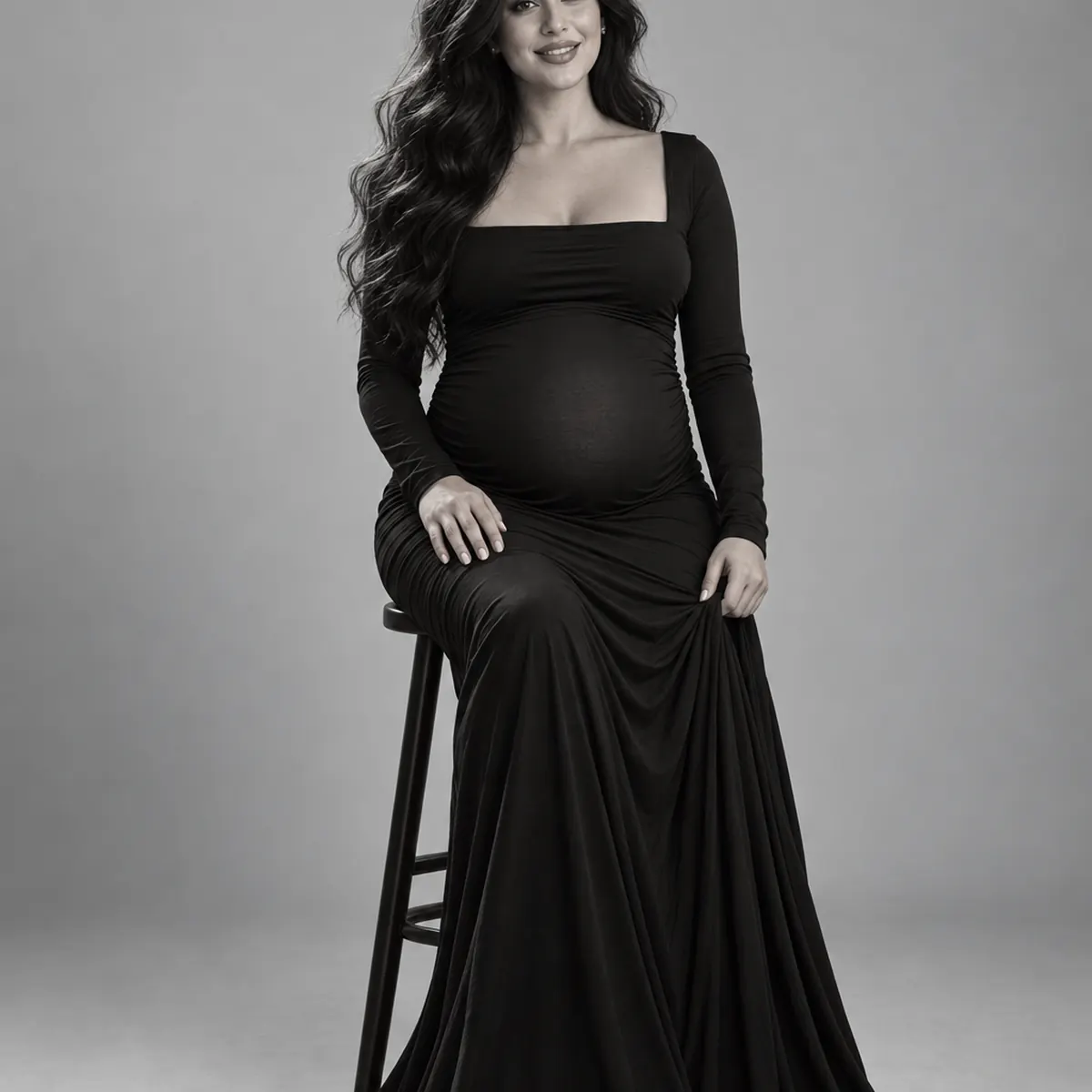 Seated black-and-white maternity portrait with direct eye contact in Markham