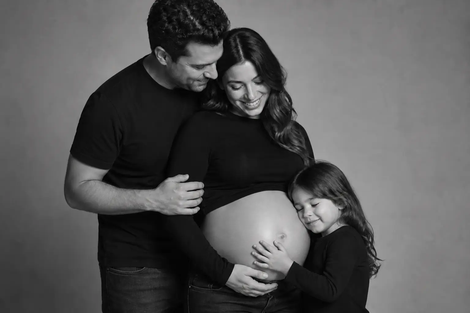 Parents and child sharing a natural moment during a family maternity photoshoot in Toronto