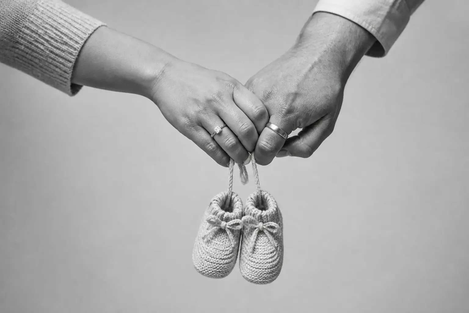 Expecting parents holding newborn booties during a Toronto maternity photo session